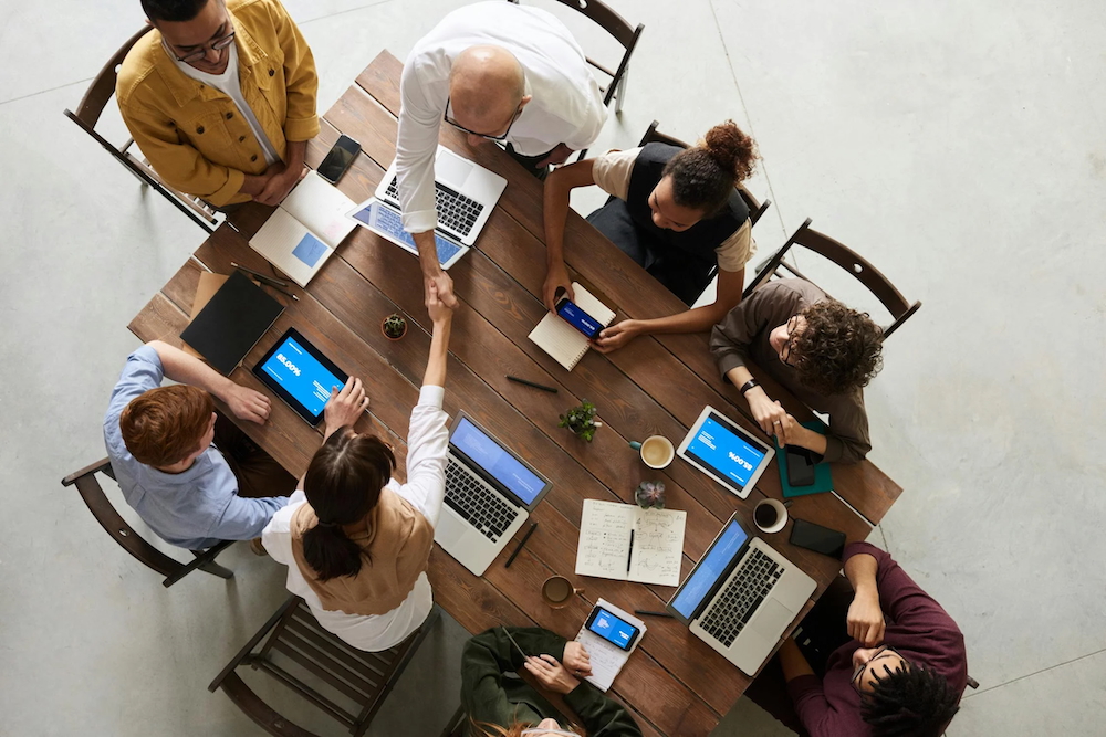 Gruppe von Leuten am Schreibtisch mit Laptops